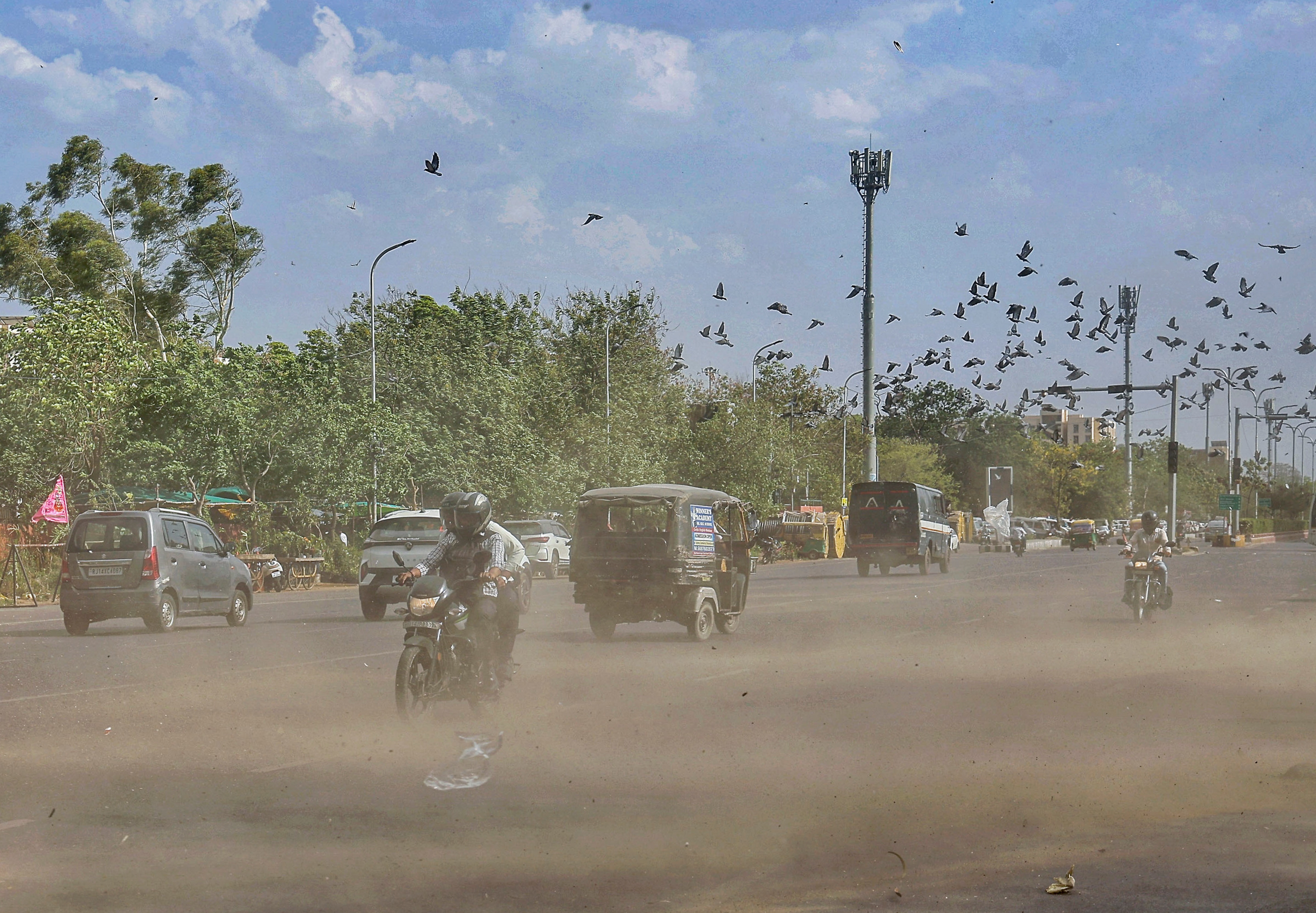 Commuters move through dust amid strong winds. (Photo: PTI)