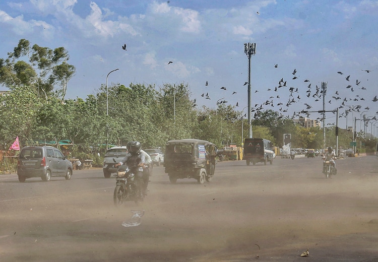 Commuters move through dust amid strong winds. (Photo: PTI)