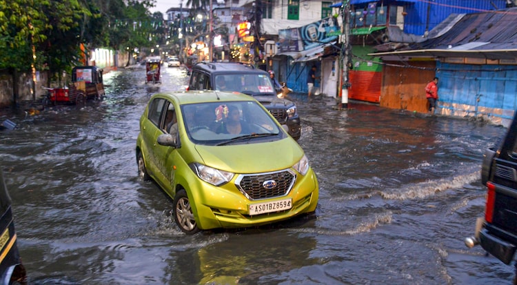 Vehicles wade through a waterlogged road following heavy rainfall, in Guwahati, Assam. (Photo: PTI)