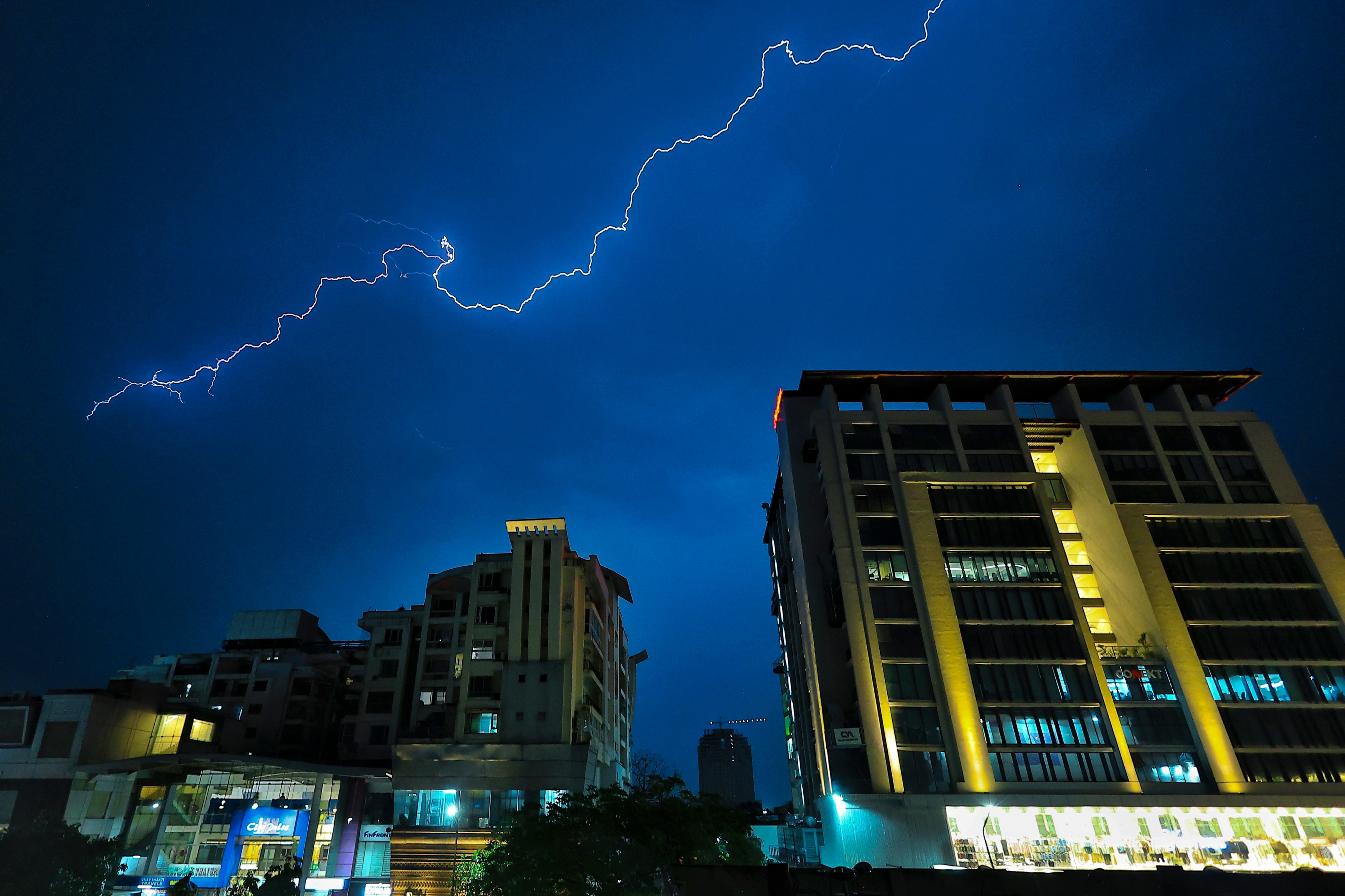  Lightning streaks across the sky over buildings during rain and thunderstorm, in Jaipur. (Photo: PTI)