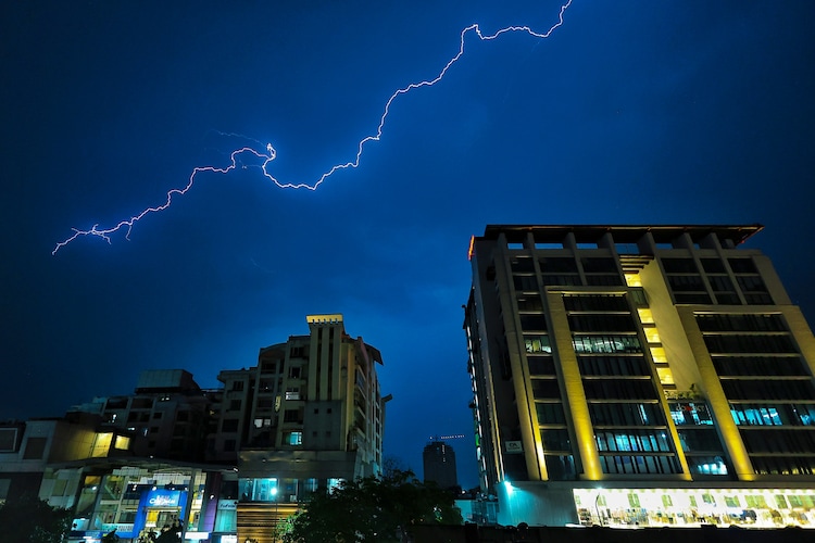 Lightning streaks across the sky over buildings during rain and thunderstorm, in Jaipur. (Photo: PTI)