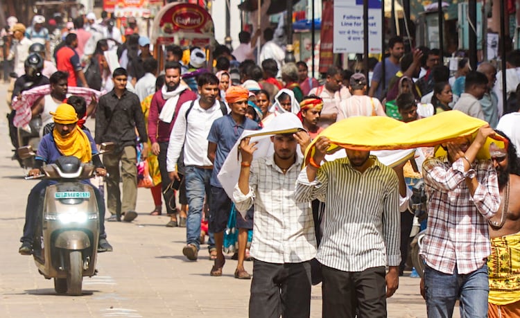 People in New Delhi walk while covering themselved from extreme heat. (Photo: PTI)