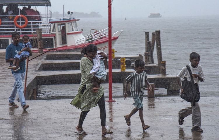 Visitors at the Marine Drive amid rain in Kochi, Kerala. (Photo: PTI)