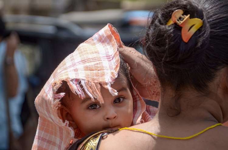 A woman covers a child on a hot summer day, in Kanpur, Uttar Pradesh. (Photo: PTI)