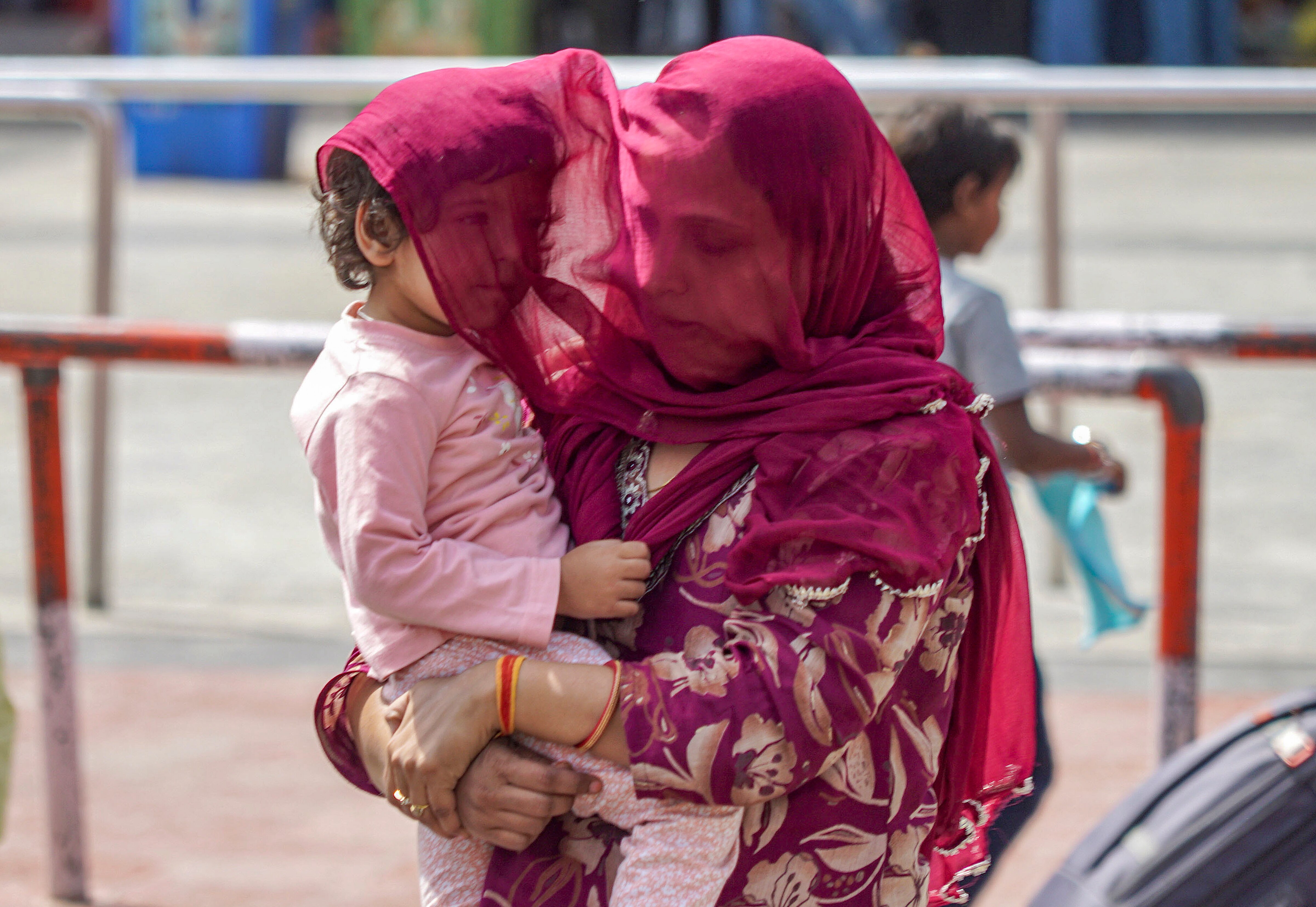  A woman covers her child amid a heatwave on a summer day, in Varanasi. (Photo: PTI)