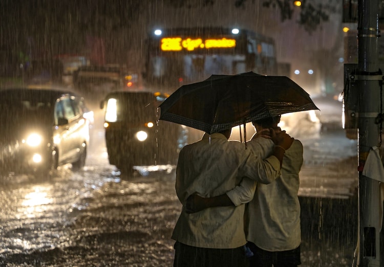 People share an umbrella on a rainy day. (Representational Photo: PTI)