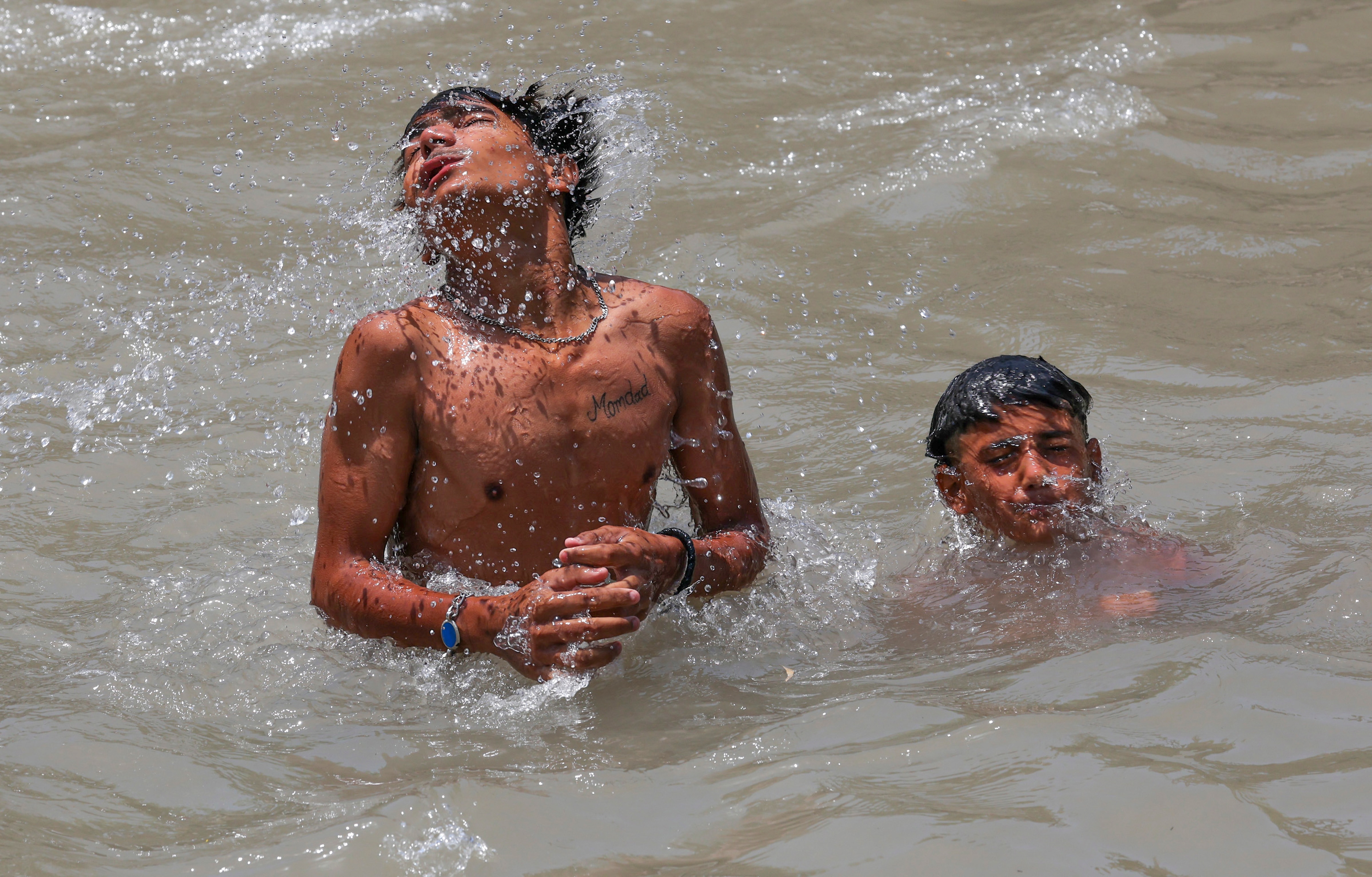 People beat the heat in a canal on a hot summer day. (Photo: PTI)