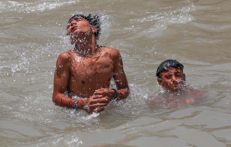 People beat the heat in a canal on a hot summer day. (Photo: PTI)
