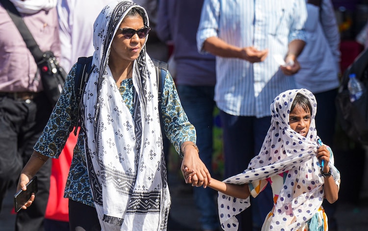 People cover themselves for protection against the heat. (Photo: PTI)