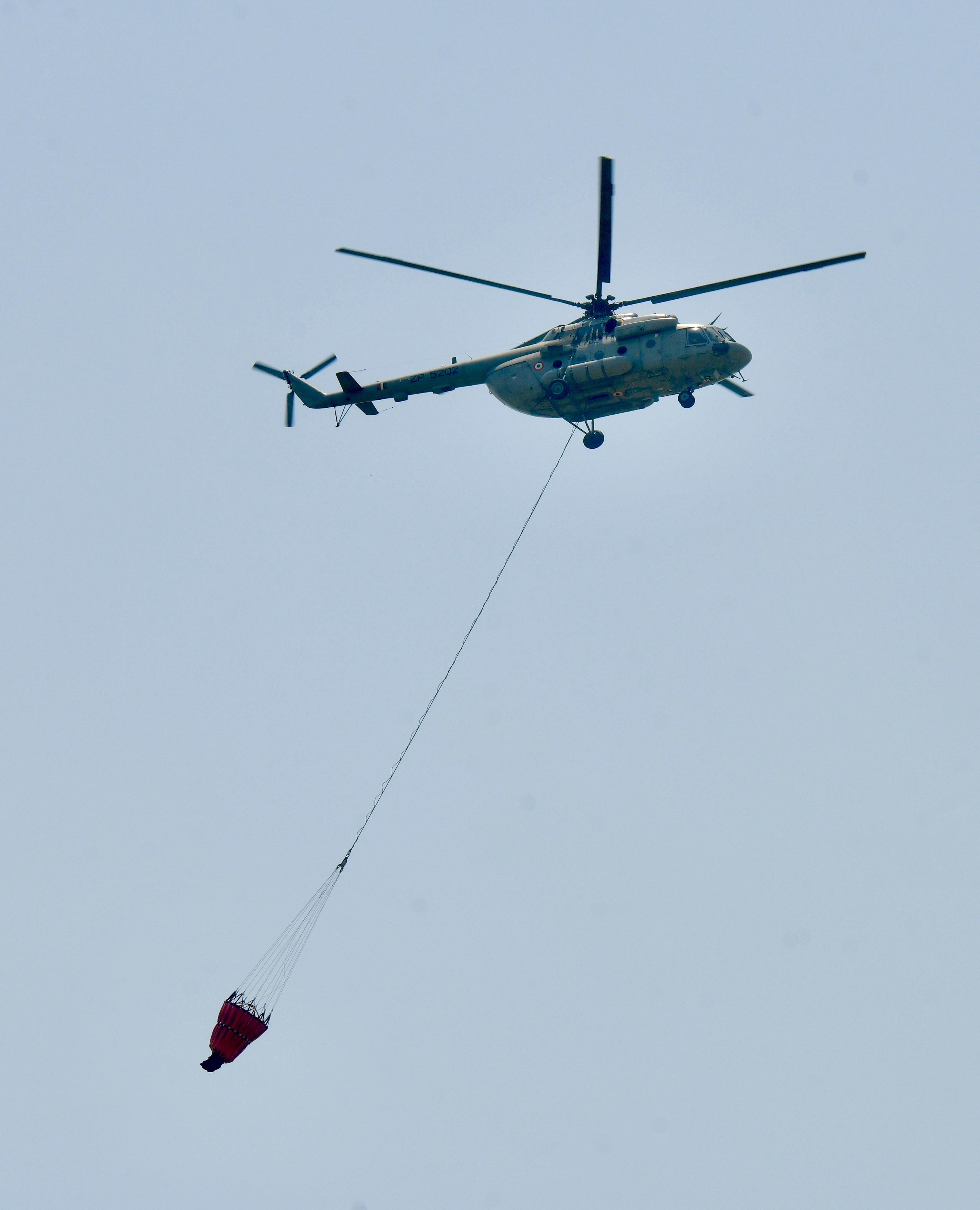 An Indian Air Force (IAF) helicopter collects water from Sukhna Lake for firefighting. (Photo: PTI)