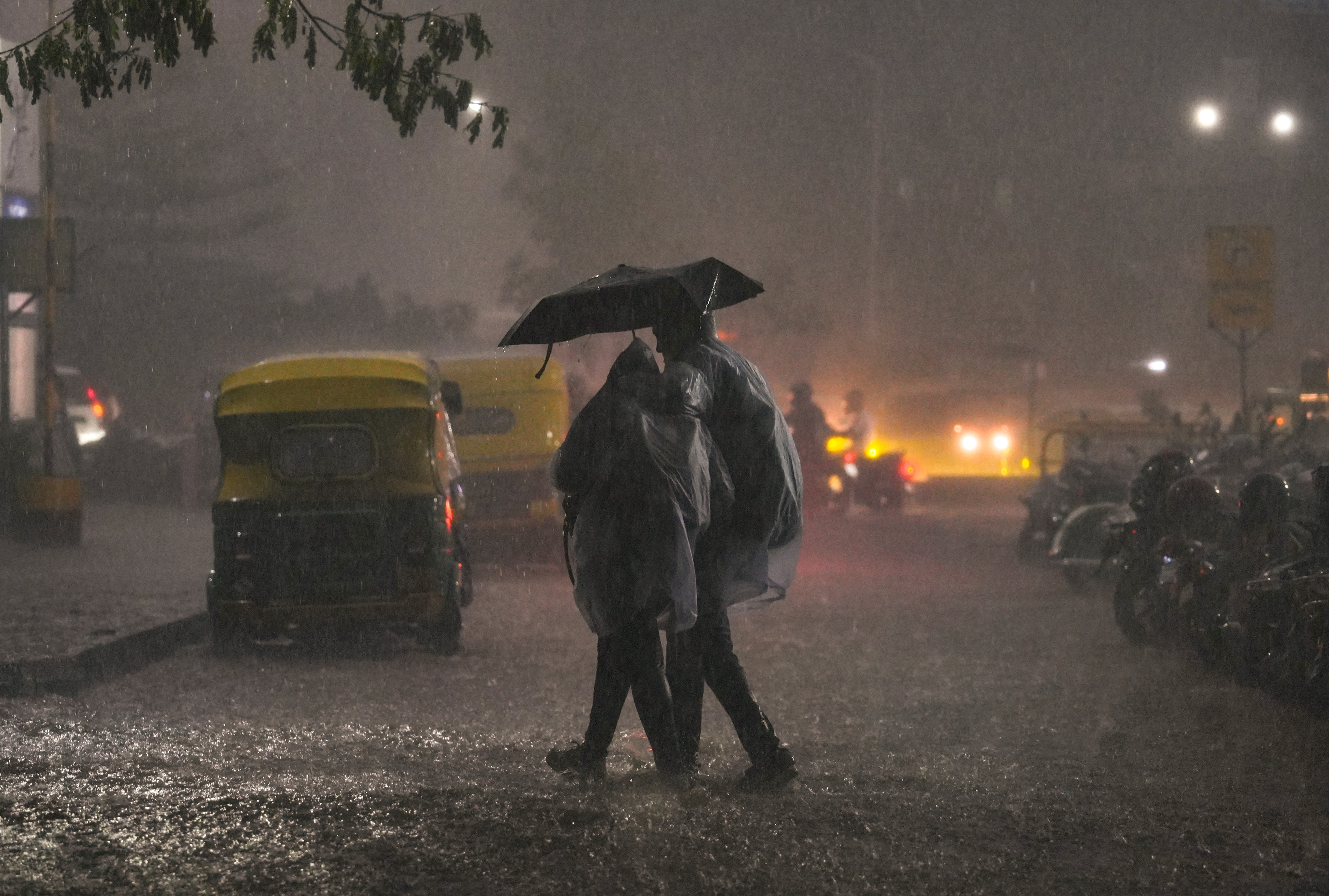People cross a road amid heavy rain. (Photo: PTI)