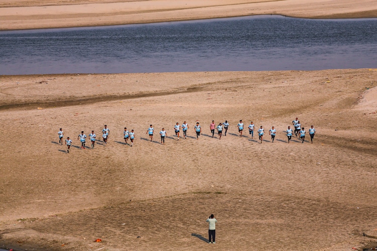 An instructor trains children on a dry patch of the Ganga riverbed. (Photo: PTI)