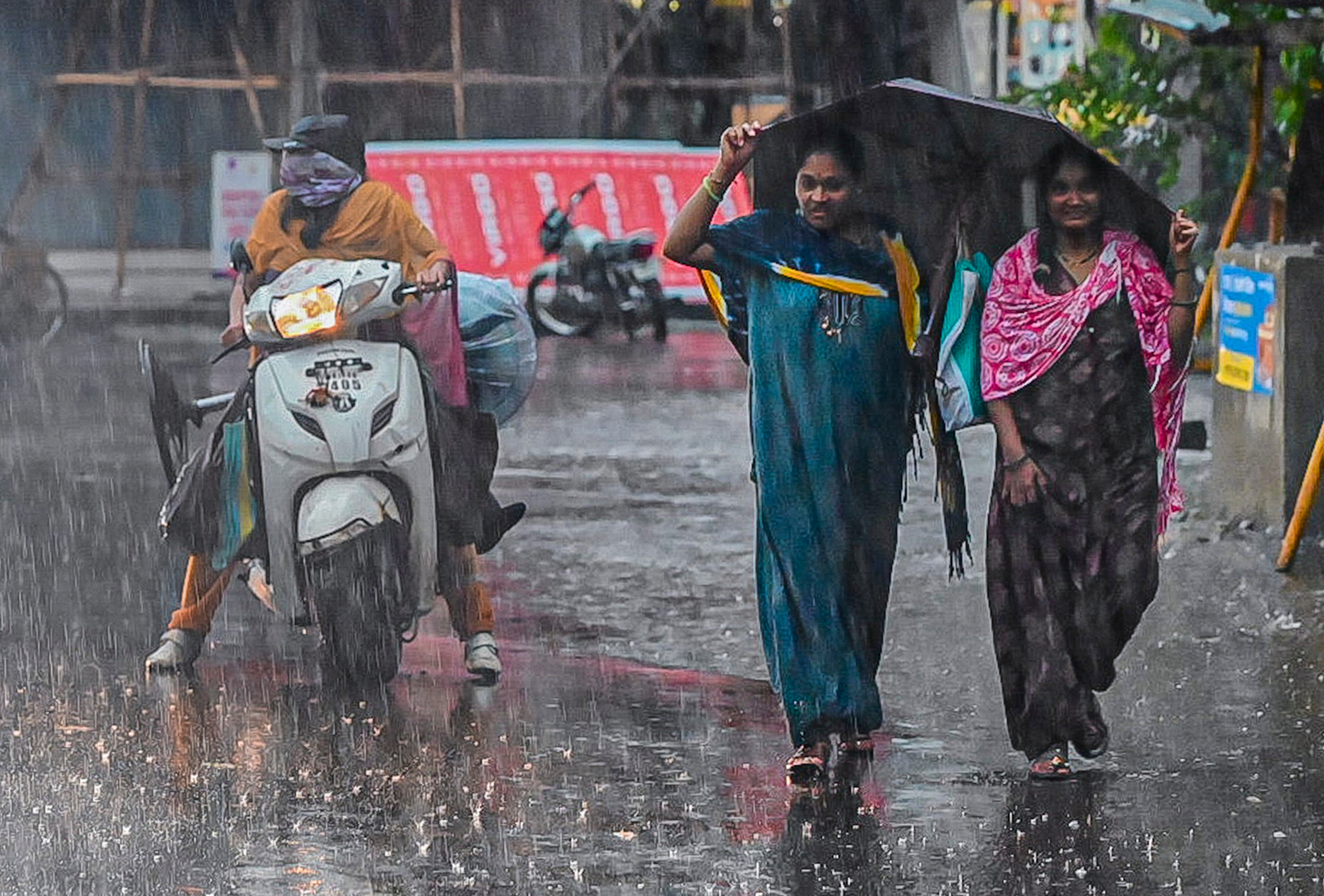 People cover themselves amid heavy rainfall, in Sangli, Maharashtra. (Photo: PTI)