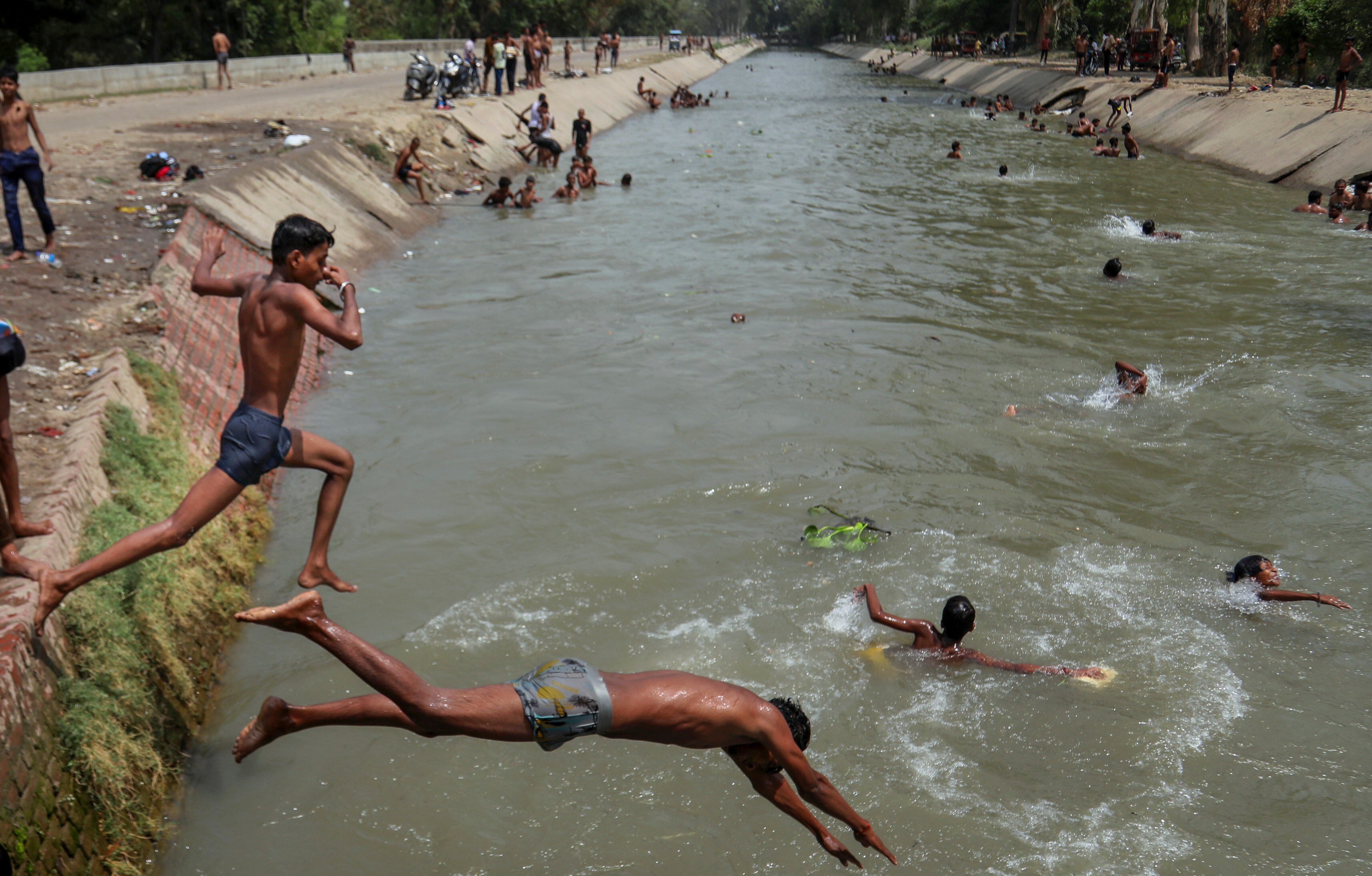 Children jump into a canal on a summer day to beat the heat. (Photo: PTI)