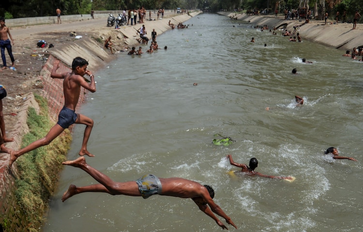 Children jump into a canal on a summer day to beat the heat. (Photo: PTI)