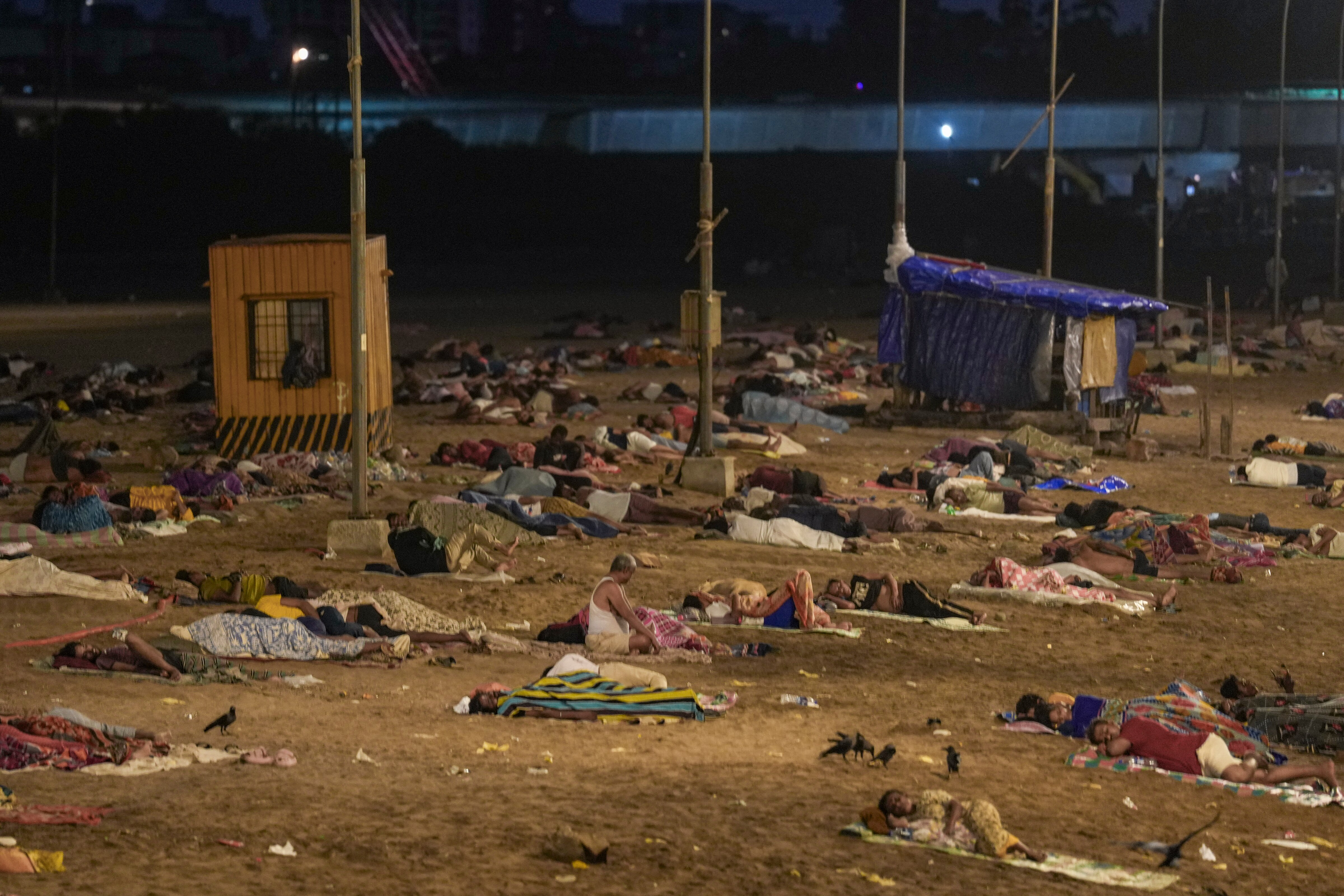 Residents sleep on Versova Beach amid intense heatwave and frequent power outages, in Mumbai. (Photo: PTI)