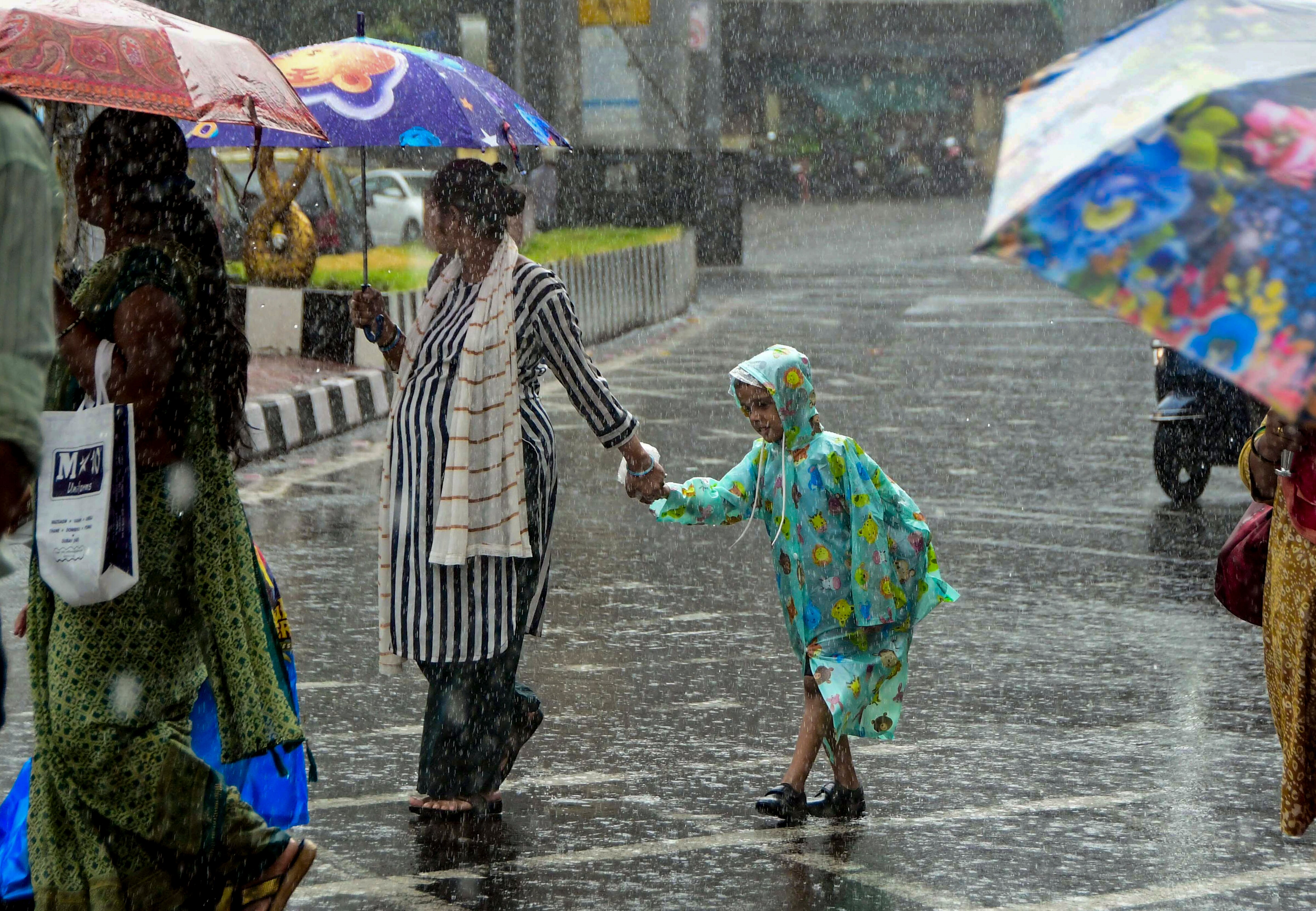 A man and his child walk amid heavy rain in New Delhi. (Photo: PTI)