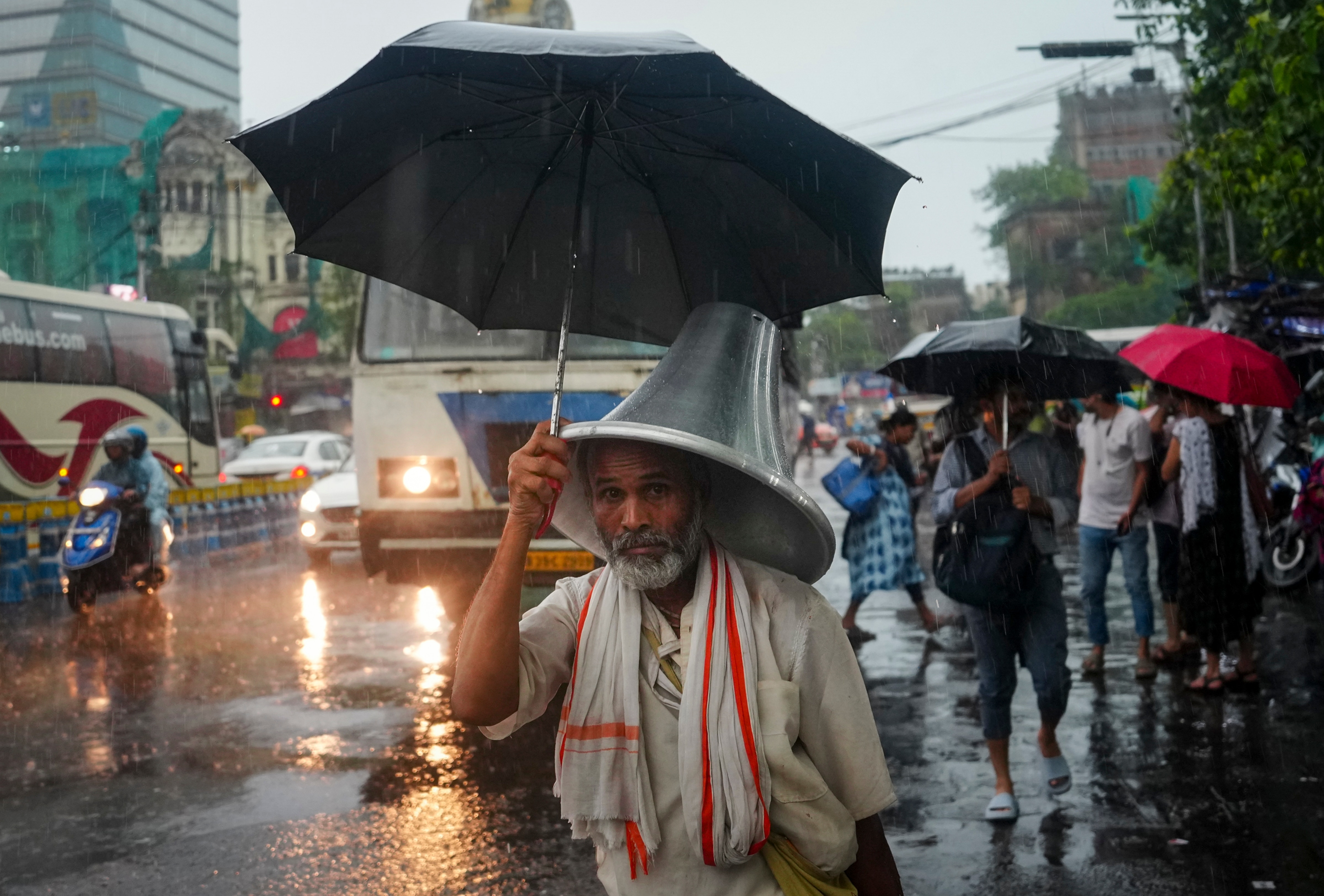 An elderly man walks with an umbrella through rain. (Photo: PTI)