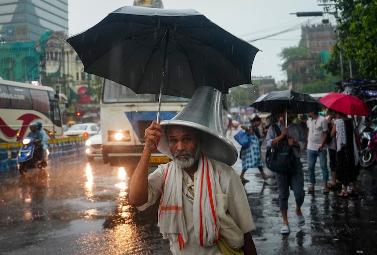 An elderly man walks with an umbrella through rain. (Photo: PTI)