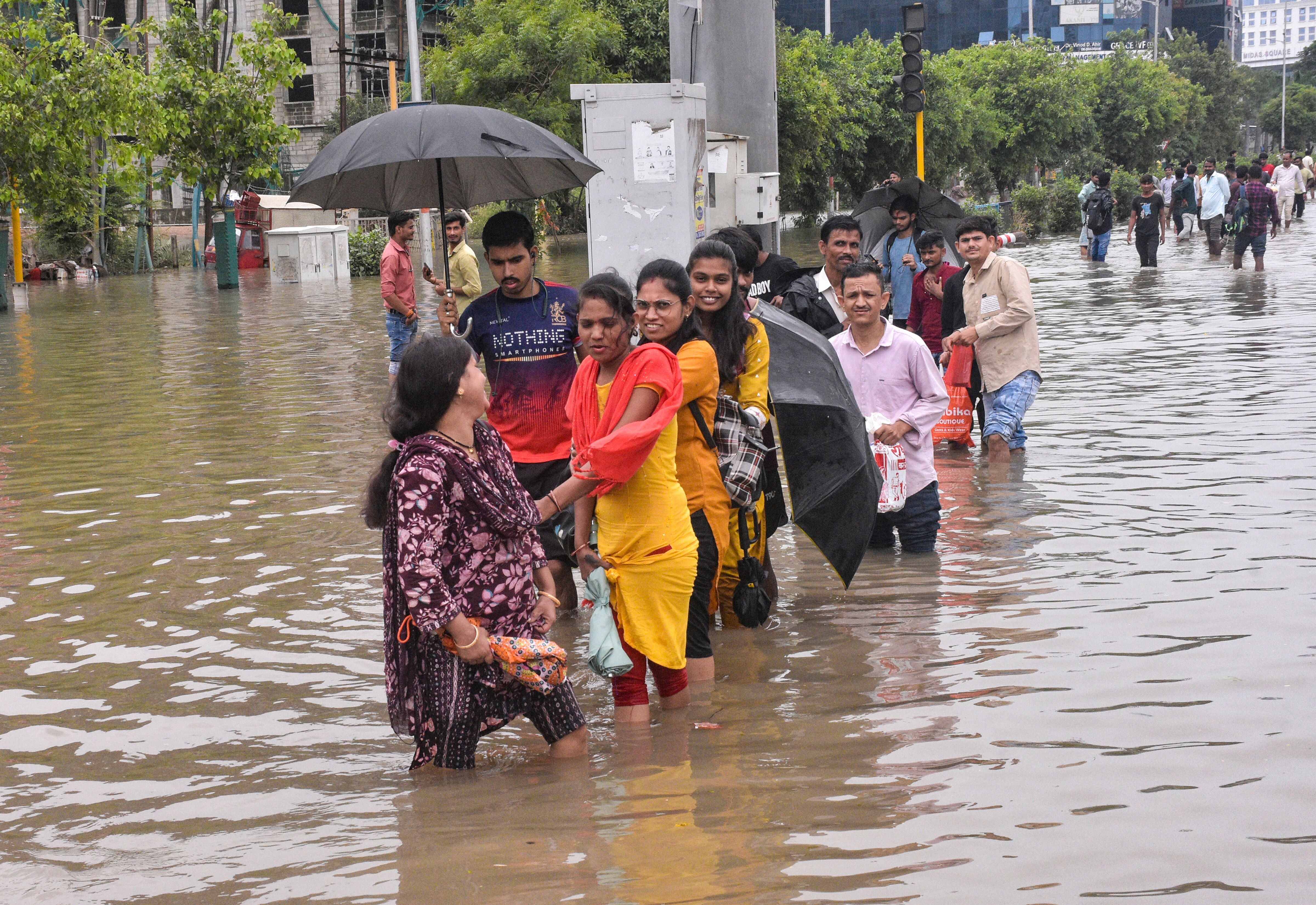 People wade through water-logged streets after heavy rainfall. (Photo: PTI))