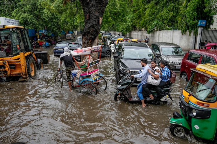 People drive through a waterlogged street after heavy monsoon rain. (Photo: PTI)