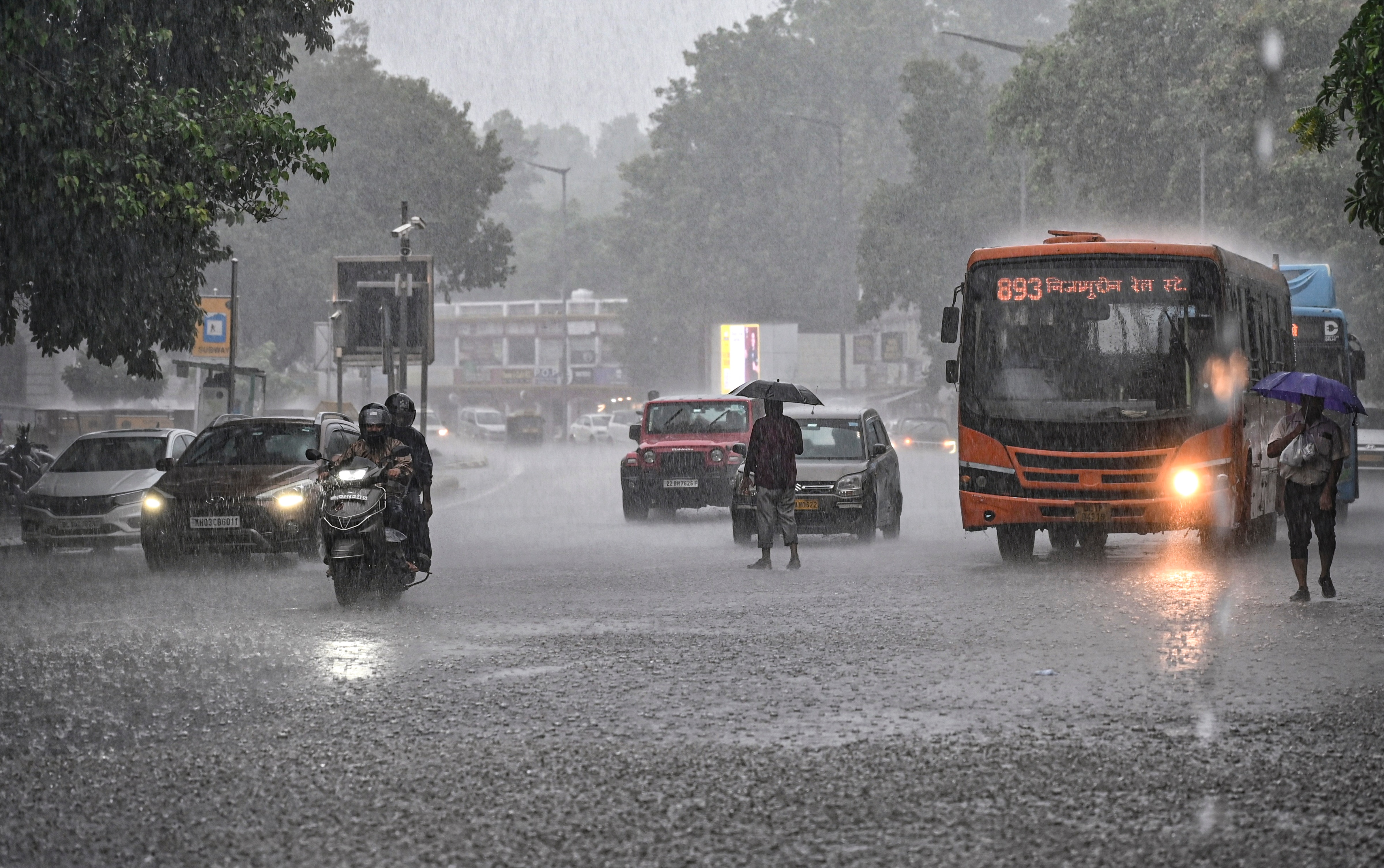Commuters make their way amid heavy rain. (Photo: PTI)