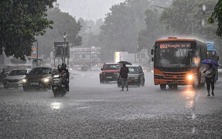 Commuters make their way amid heavy rain. (Photo: PTI)