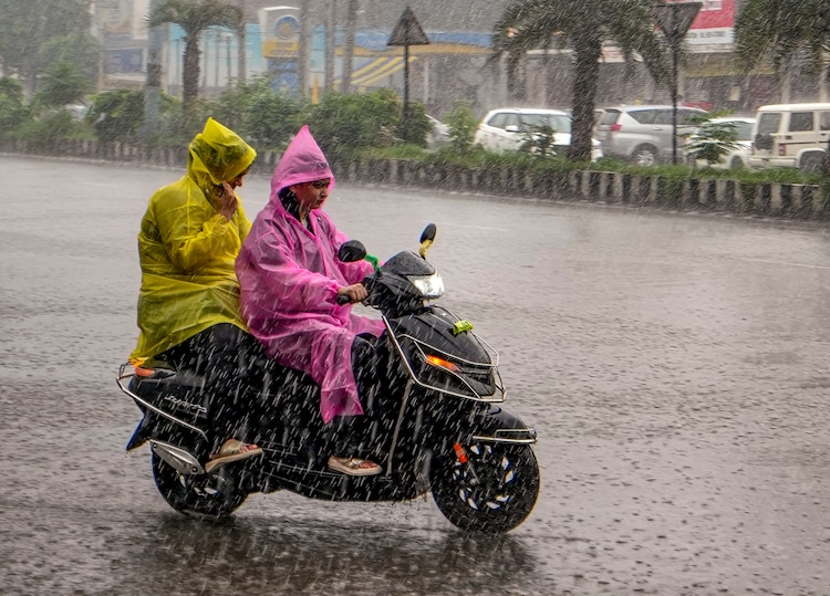 Commuters make their way amid heavy rain. (Photo: PTI)