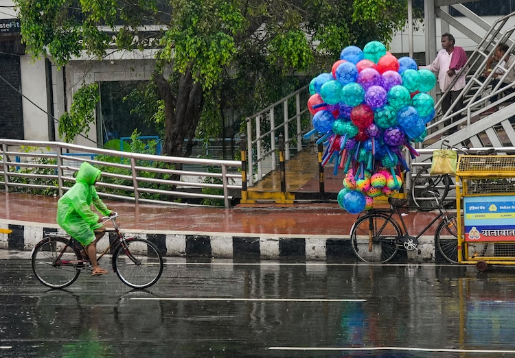A person rides a bicycle amid rain. (Photo: PTI)