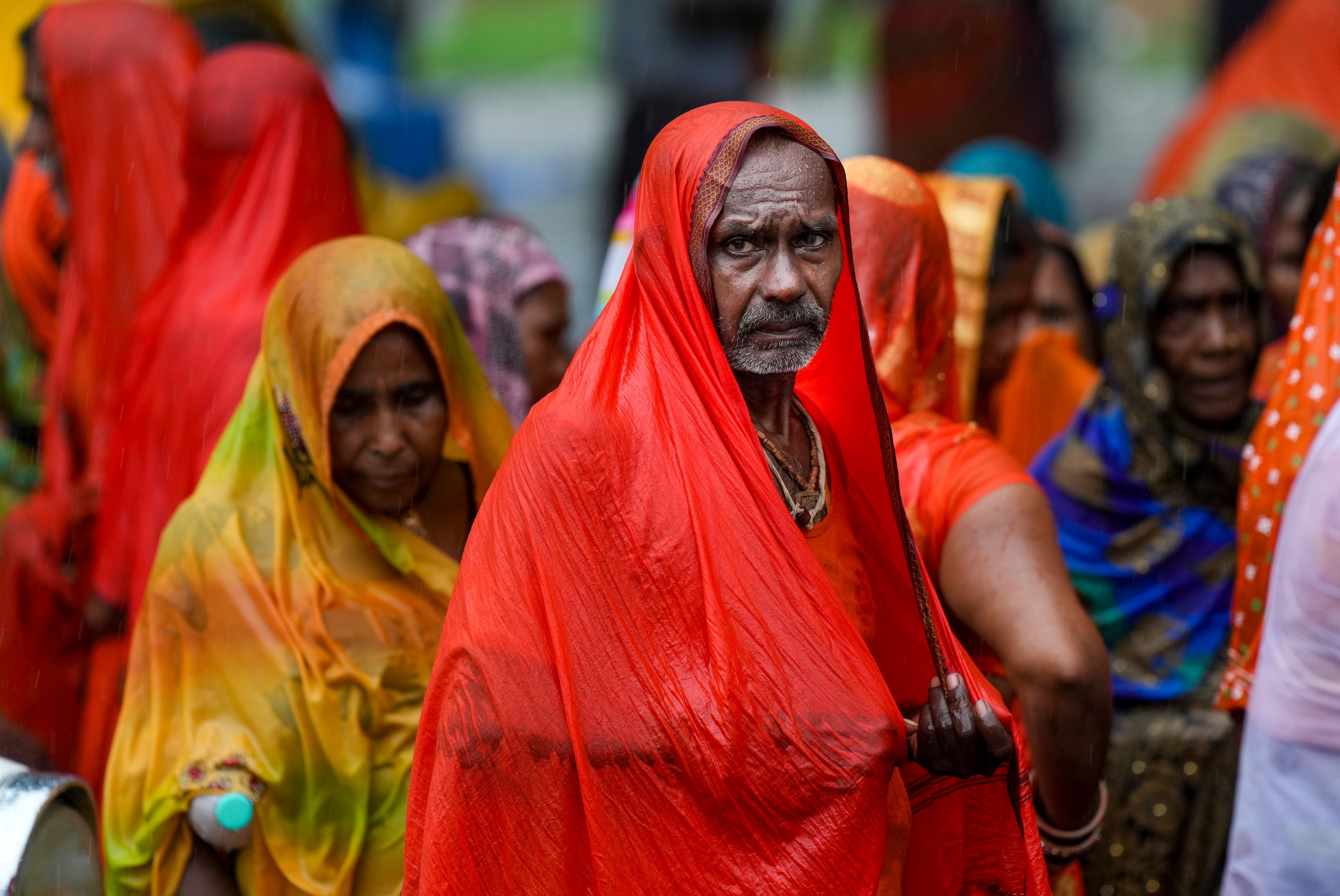 A man covers himself with a plastic sheet during a monsoon rain shower. (Photo: PTI)