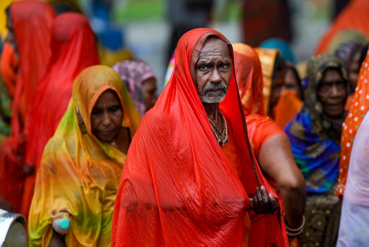 A man covers himself with a plastic sheet during a monsoon rain shower. (Photo: PTI)