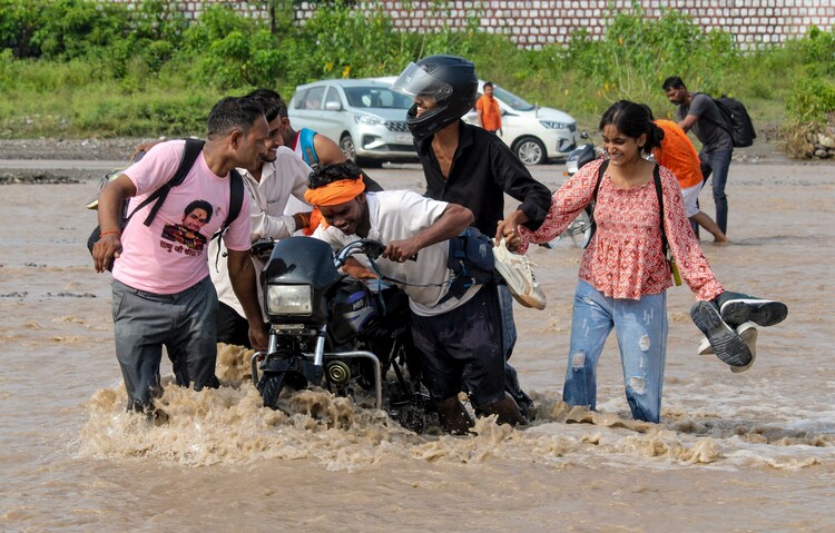 Commutters move along a inundated area. (Photo: PTI)