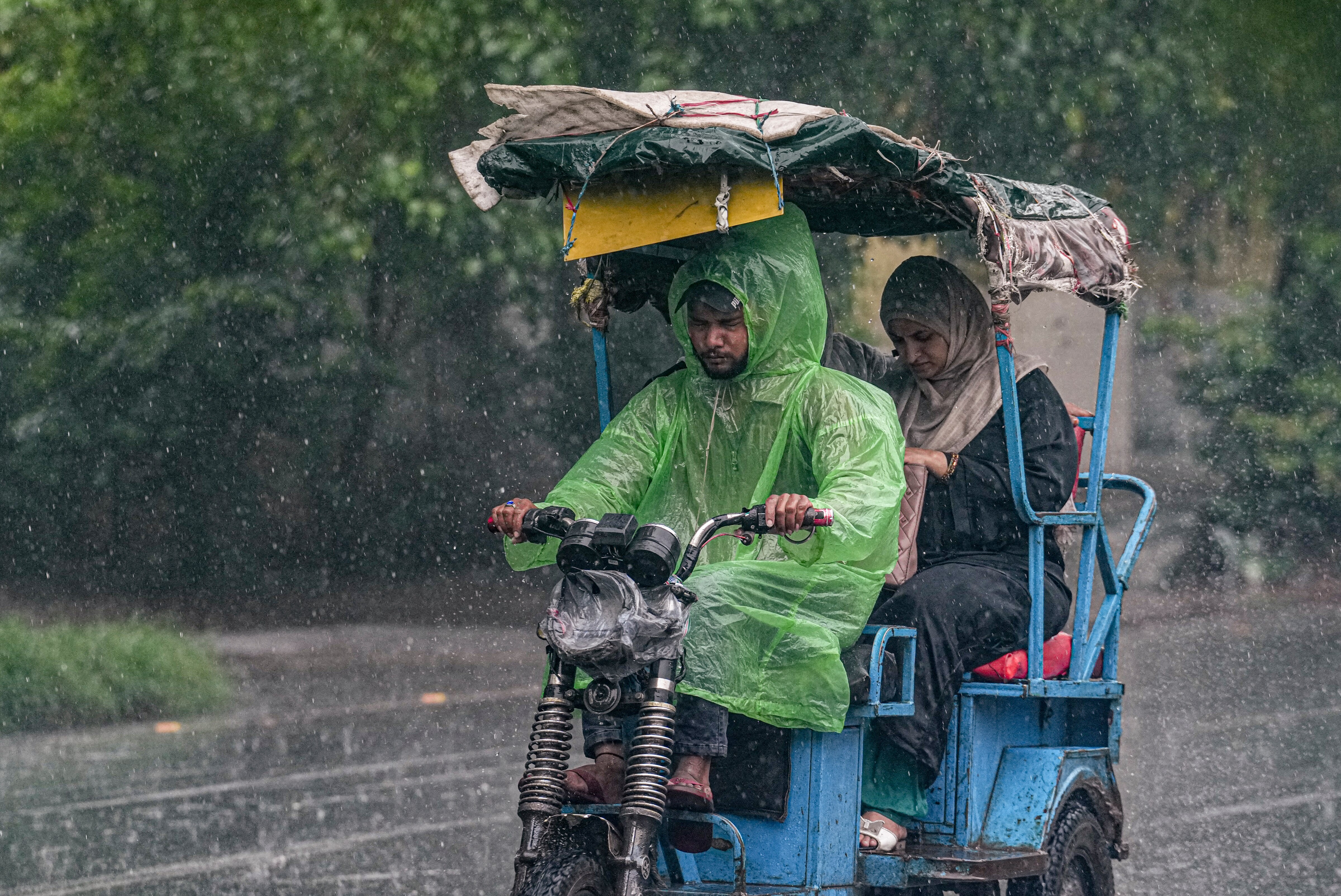 A man drives an e-rickshaw amid monsoon rain, in New Delhi. (Photo: PTI)