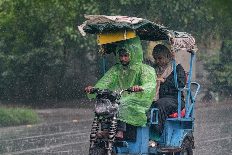 A man drives an e-rickshaw amid monsoon rain, in New Delhi. (Photo: PTI)