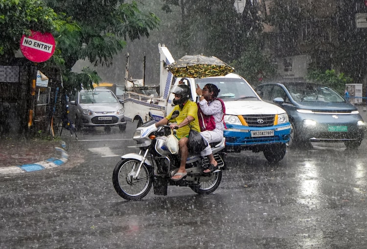 Commuters ride a two-wheeler during monsoon rainfall. (Photo: PTI)