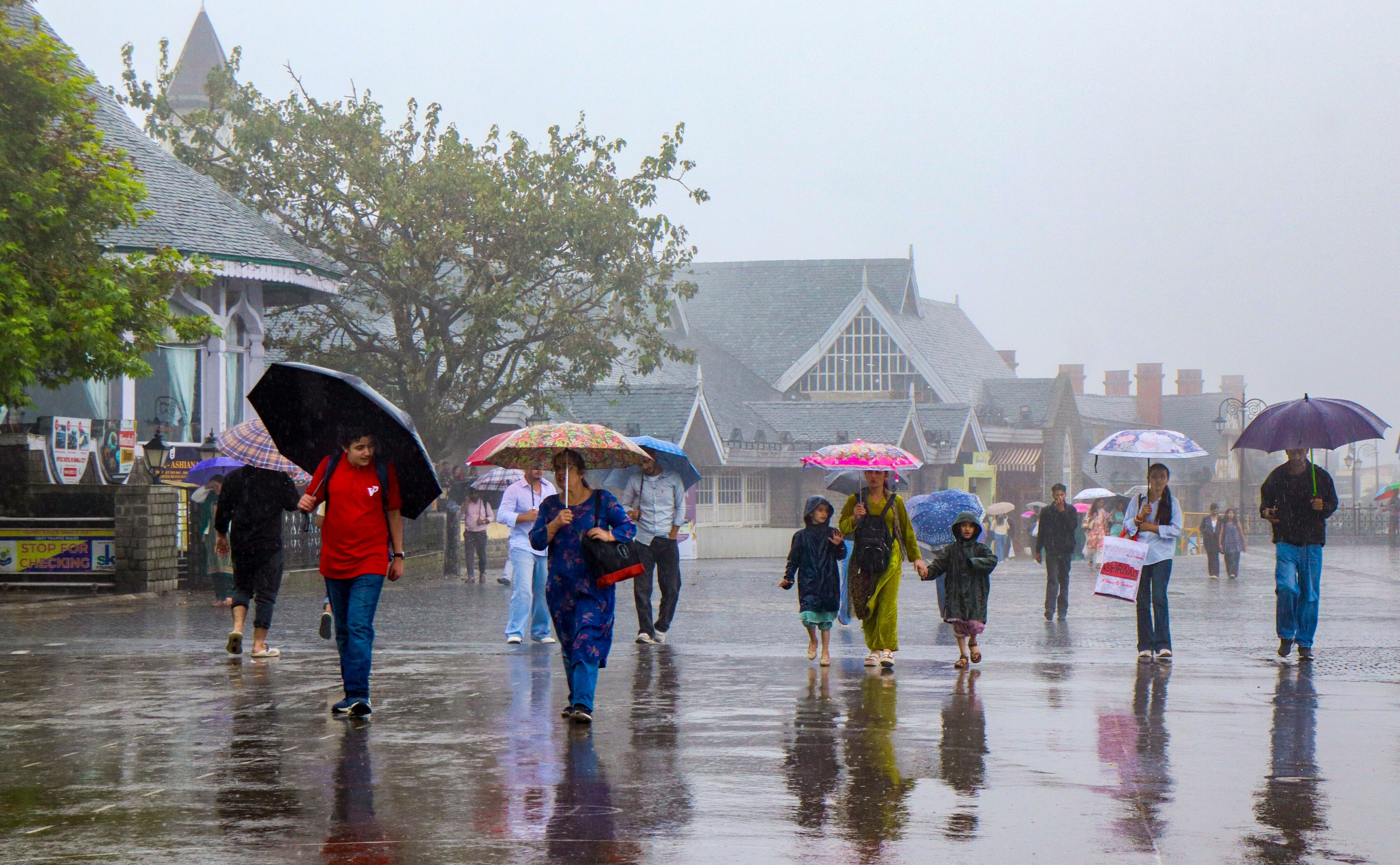 People cover themselves as they walk amid rain. (Photo: PTI)