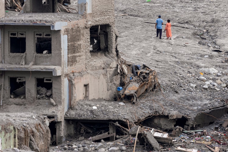Residents walk amid mud and debris days after the flash flood in Nepal. (Photo: PTI)