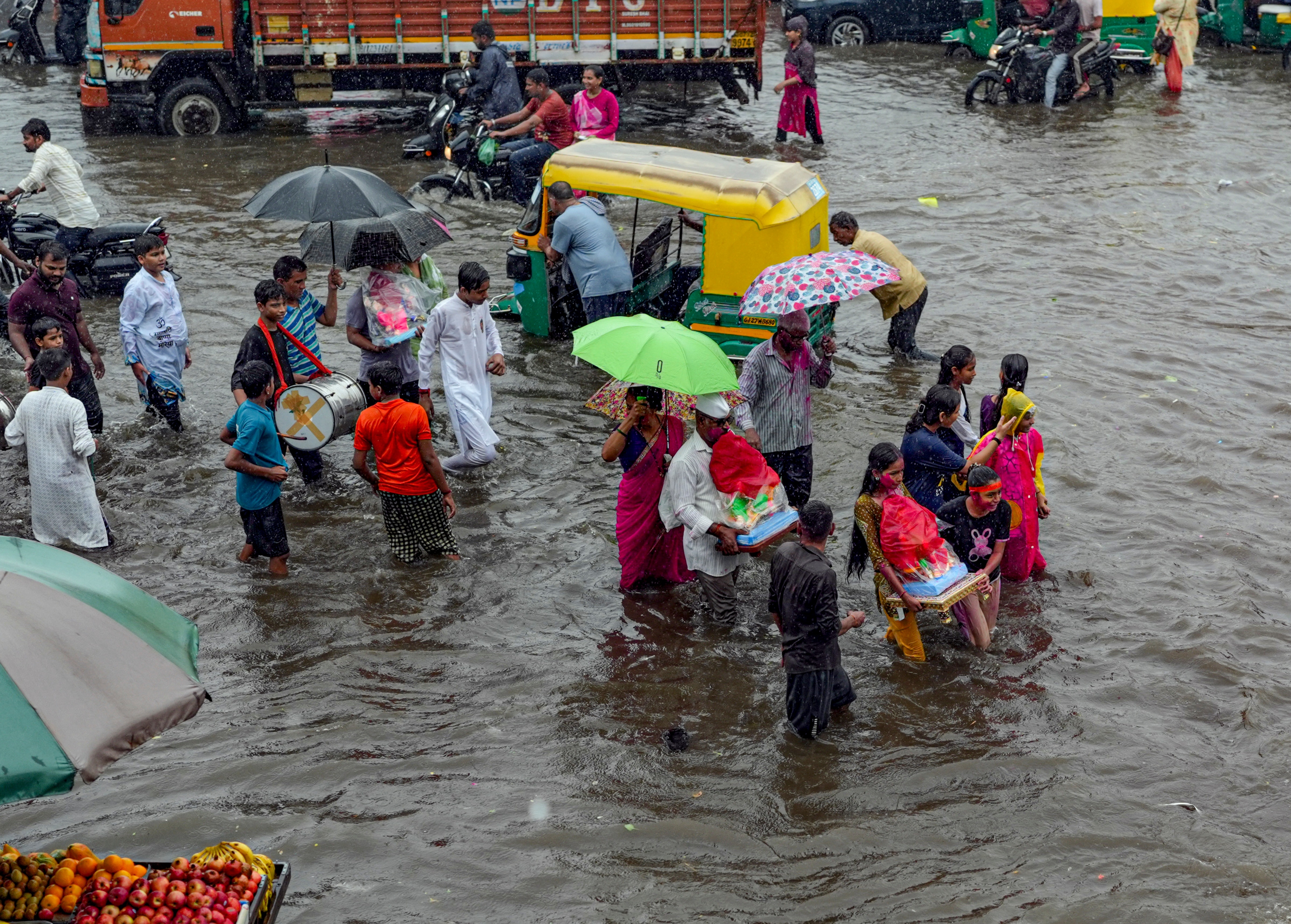 People wade through water-logged streets after heavy rainfall. (Photo: PTI)