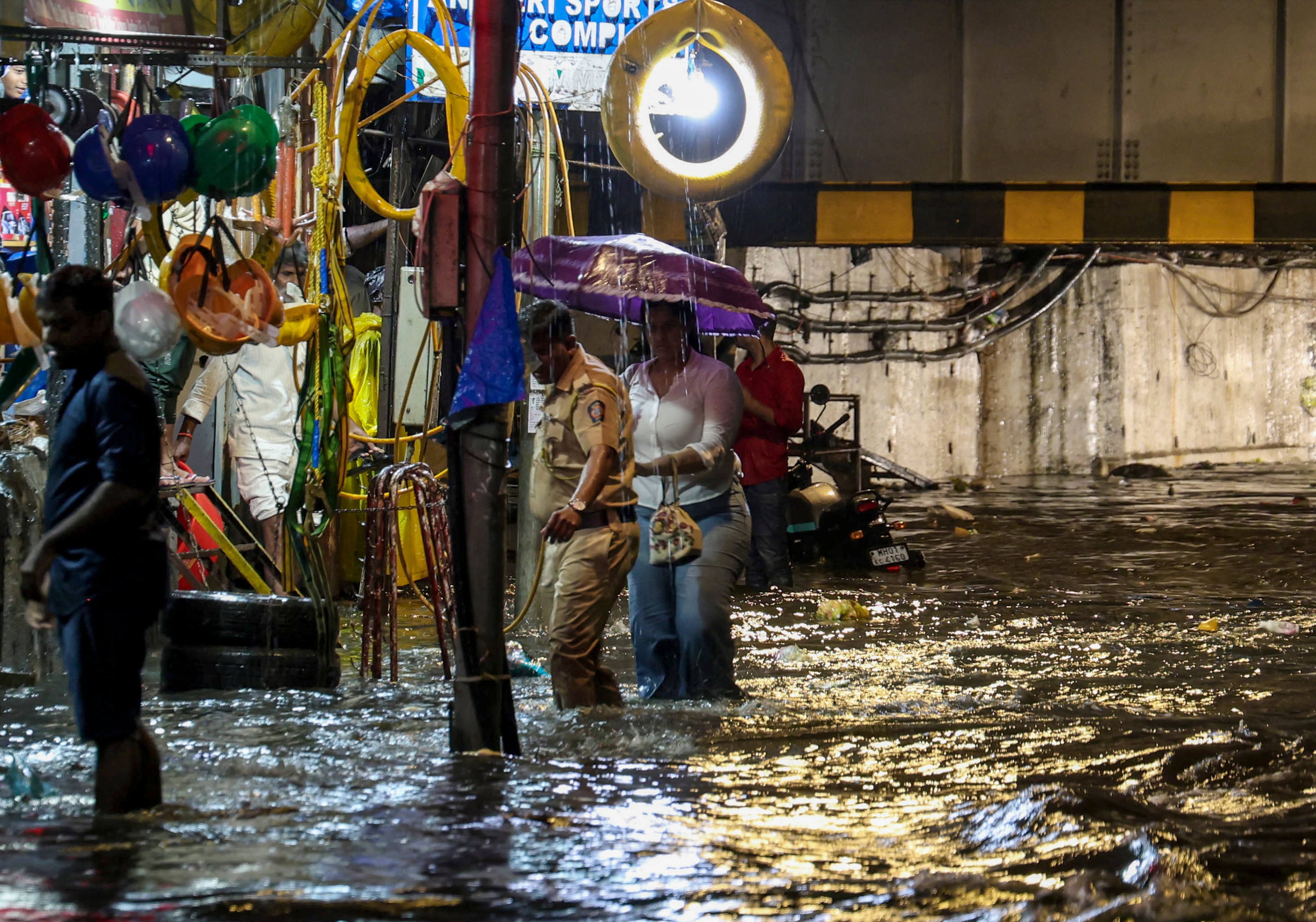 People move on a waterlogged road following rain, in Mumbai. (Photo: PTI)