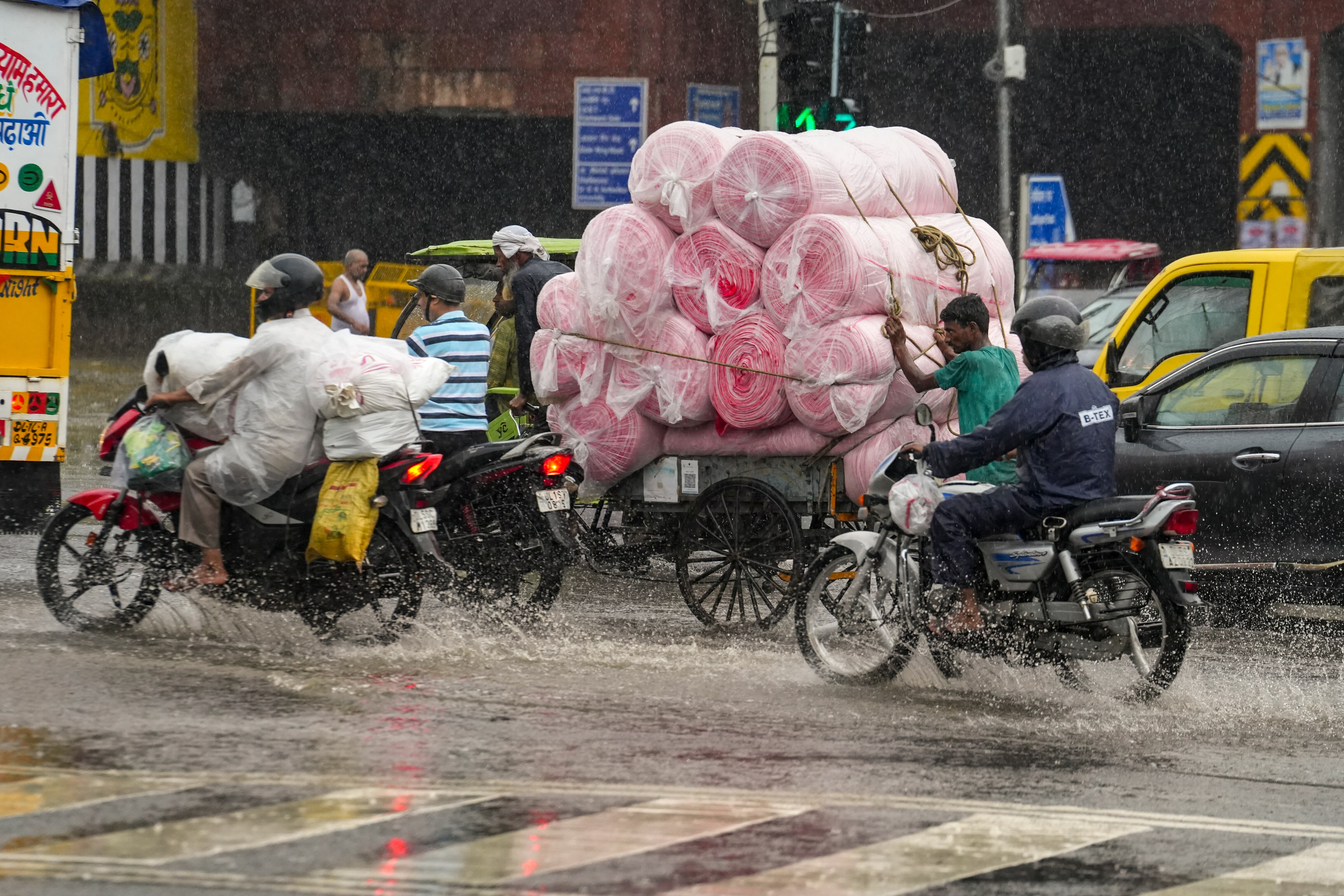 Commuters make their way amid rain in New Delhi. (Photo: PTI)