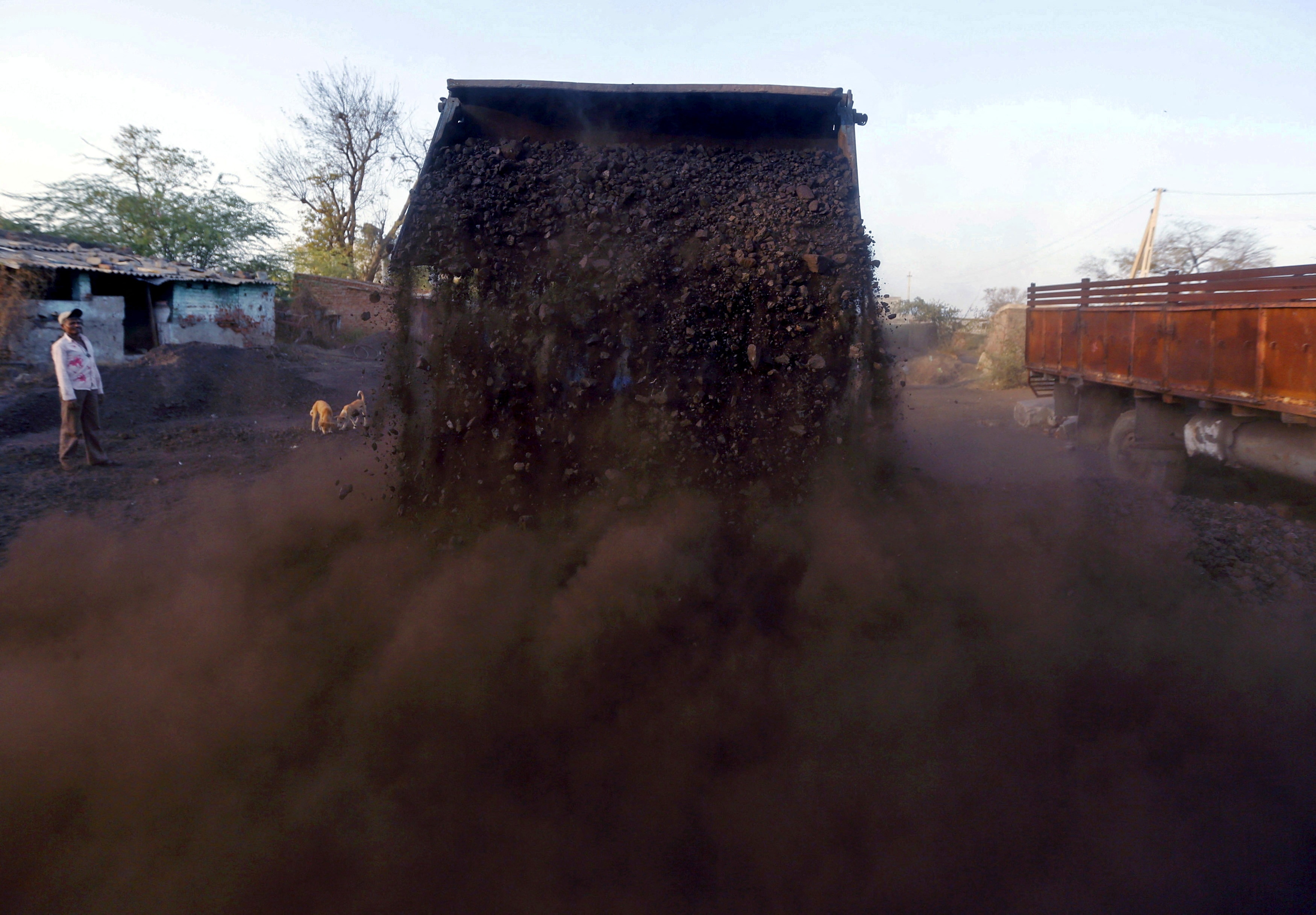  A worker watches as a loader unloads coal at a yard near Ahmedabad. (Photo: Reuters)