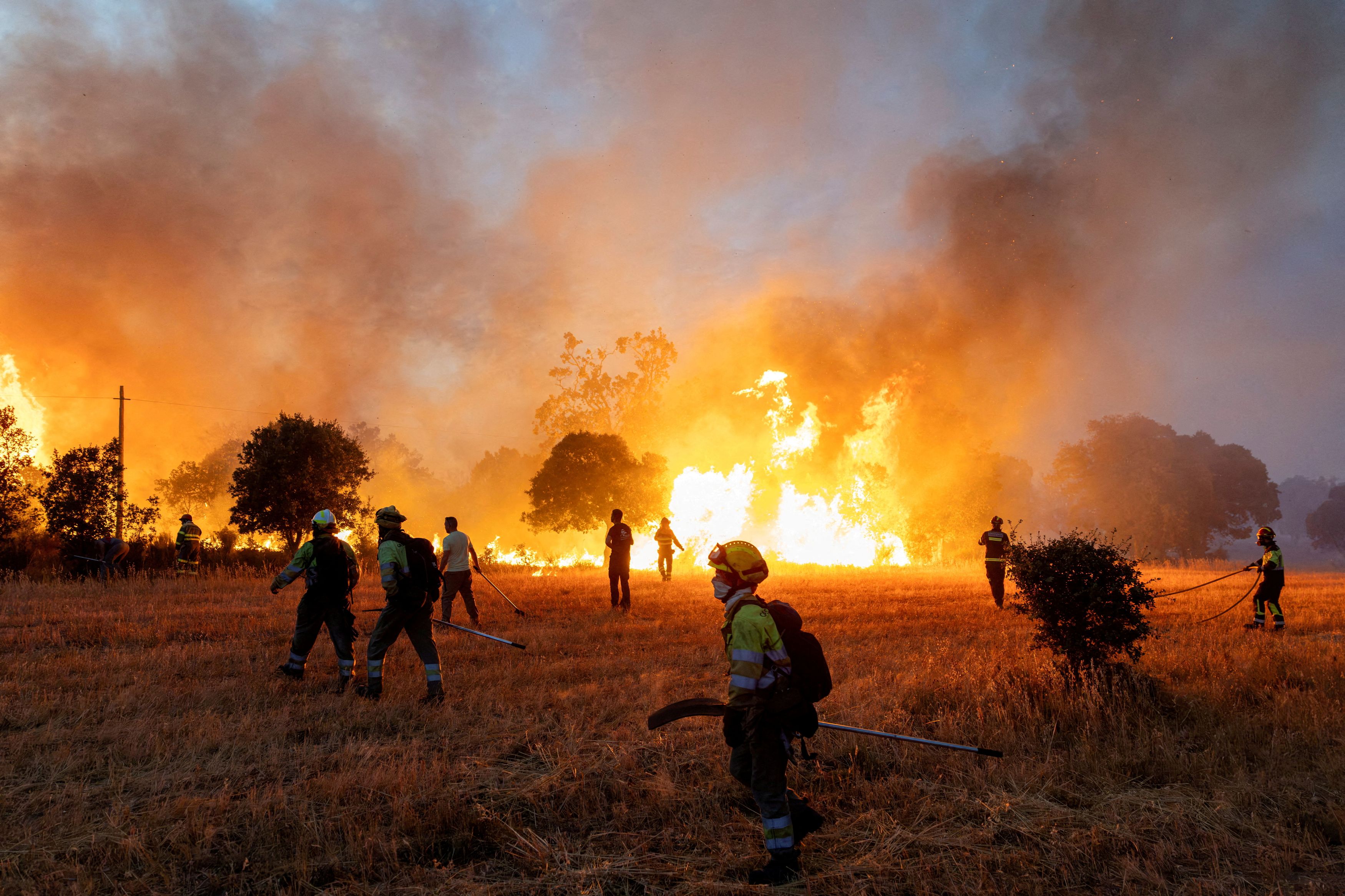 Residents and firefighters work to extinguish an advancing wildfire in Spain.(Photo: Reuters)