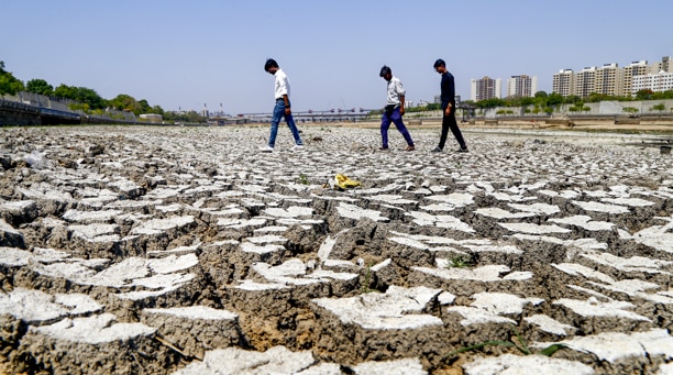 People walk on a dried riverbed of Sabarmati river during a drought. (Photo: PTI)
