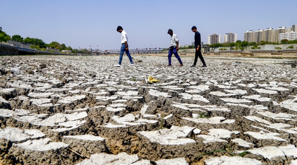 People walk on a dried riverbed of Sabarmati river during a drought. (Photo: PTI)