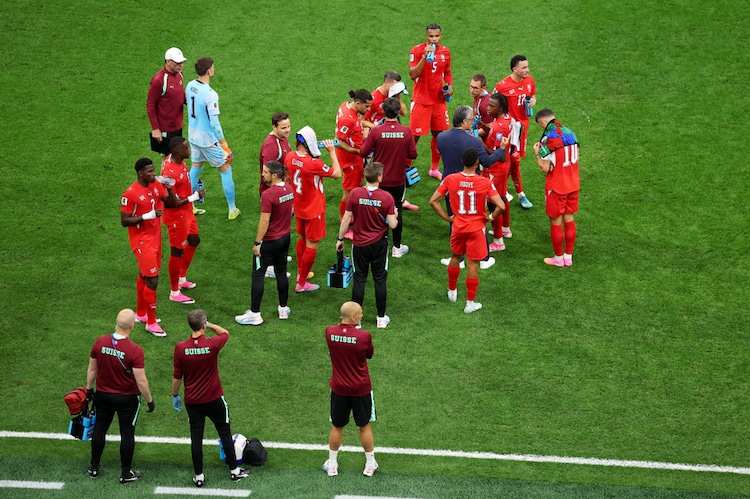 Switzerland players cool off during a hydration break. (Photo: AFP)