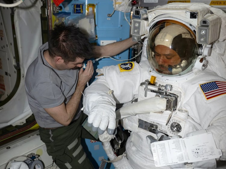 Nasa's Jack Hathaway assists astronaut Anil Menon aboard the ISS. (Photo: Nasa)