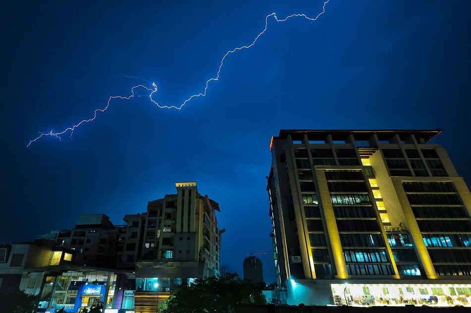 Lightning streaks across the sky over buildings during rain and thunderstorm. (Photo: PTI)