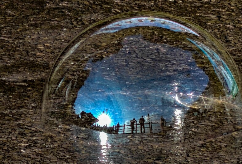 A bubble reflects people standing near a railing after rain. (Photo: PTI)