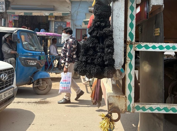 A man walks on a dusty road with his face covered. (Photo: ITG/Aryan Rai)
