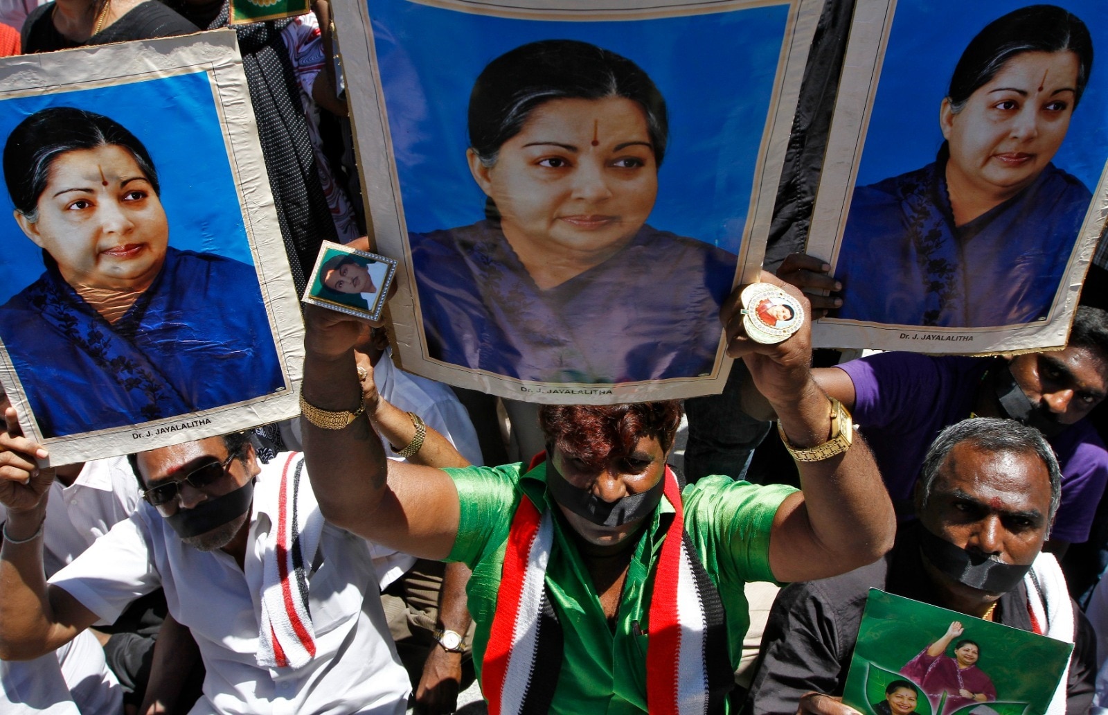 Supporters of Jayalalithaa hold her posters as they sit on a fast during a protest against the court verdict in Chennai. (Reuters)